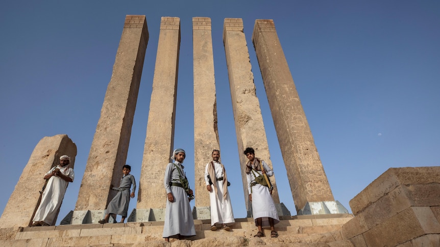 soldiers pose on the steps of the Awwam Temple in Yemen
