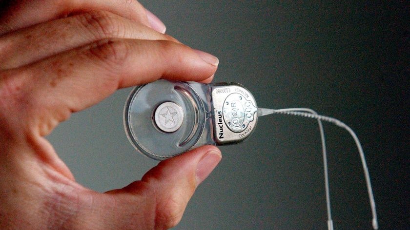 A person holds a Cochlear implant