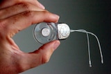 A person holds a Cochlear implant.