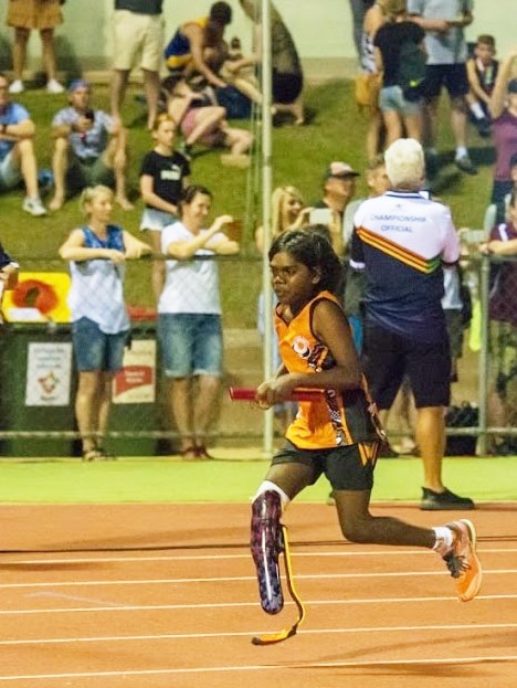 One legged girl running on athletics track