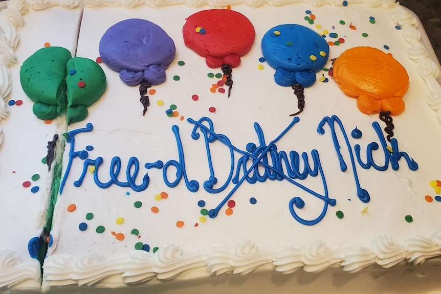 A cake with 'Free Britney' written on it, with 'Britney' crossed out and replaced with 'Nick' 