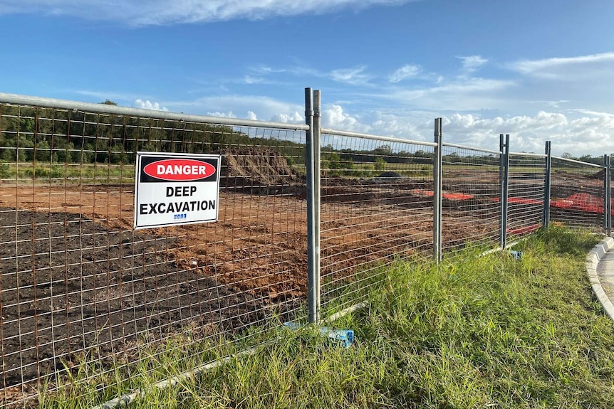 Construction site fencing and danger, deep excavation sign at the North Harbour residential and marina development.