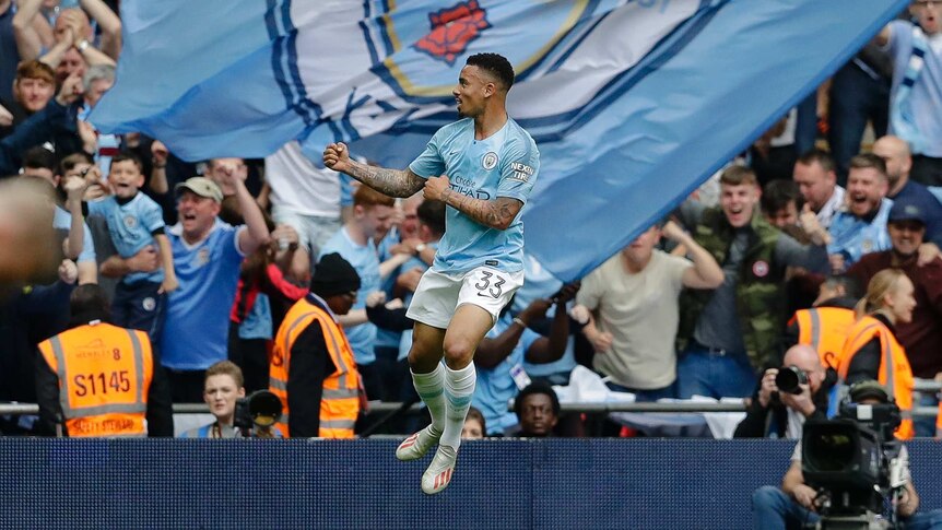 Gabriel Jesus jumps in front of giant Manchester City flag