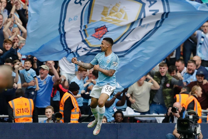 Gabriel Jesus jumps in front of giant Manchester City flag