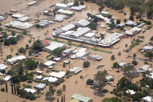 The town of Theodore, buildings, cars swamped by brown, murky flood water, birds eye view.