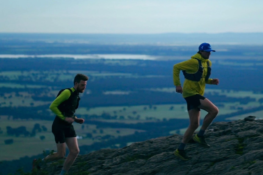 two runners on the top of a mountain ridge in regional victoria