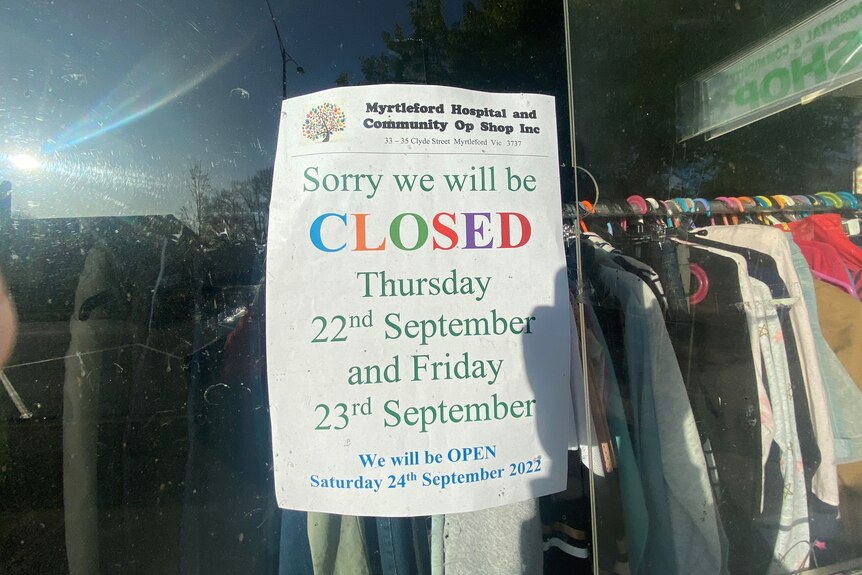 A sign for public holiday trading hours in an op shop window saying the store will be closed for Thursday and Friday