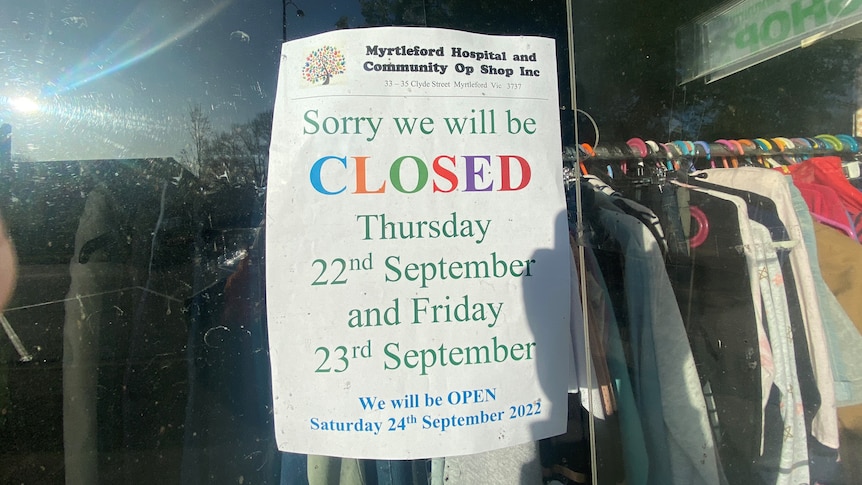 A sign for public holiday trading hours in an op shop window saying the store will be closed for Thursday and Friday