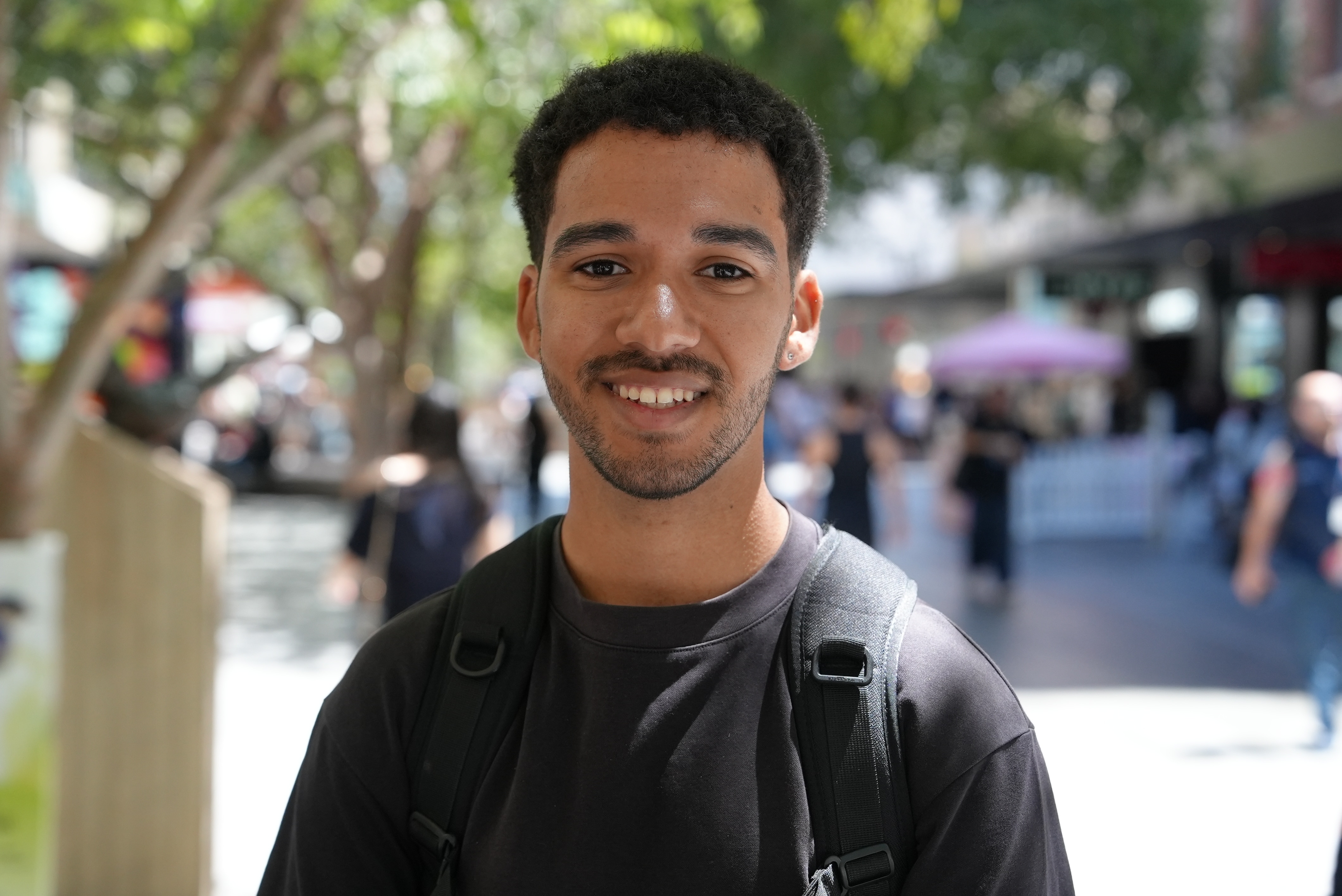 Un joven de cabello castaño y camiseta negra.