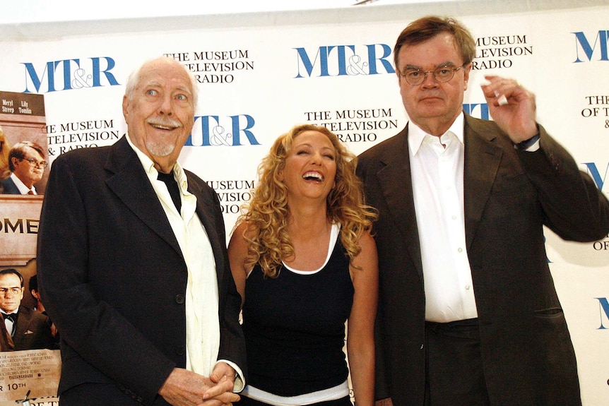 Director Robert Altman, left, with smiling cast member Virginia Madsen and Garrison Keillor in the right in a suit and glasses