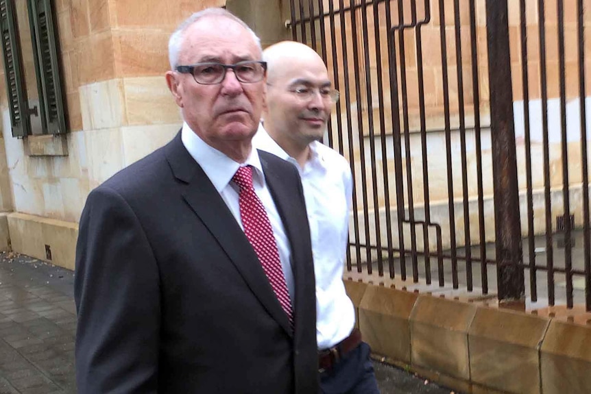 Dayang Wang (right) leaves Adelaide Magistrates Court with his lawyer.