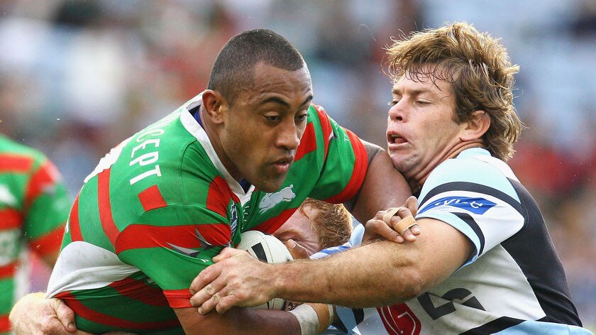 Roy Asotasi of the Rabbitohs is tackled by Brett Kimmorley of the Sharks during the round 15 NRL mat
