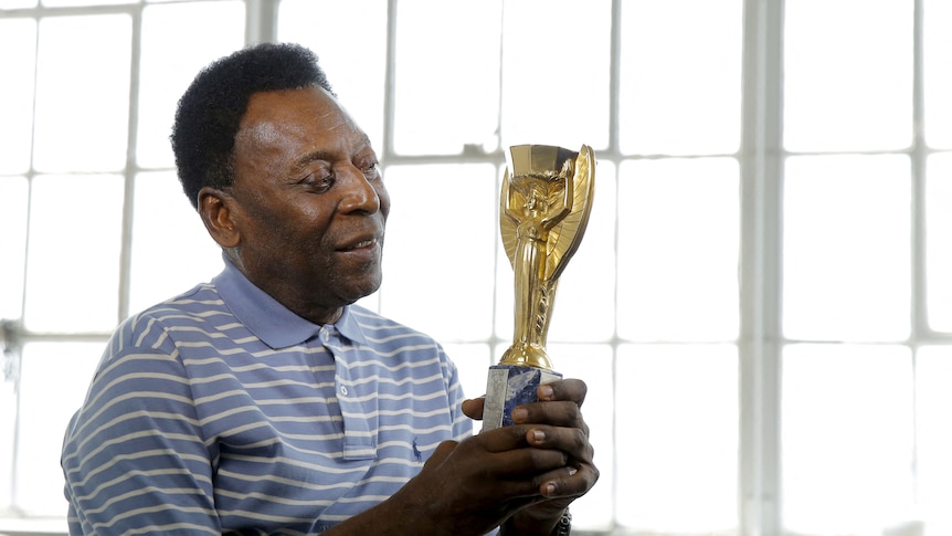 Pele poses with his 1958 World Cup trophy