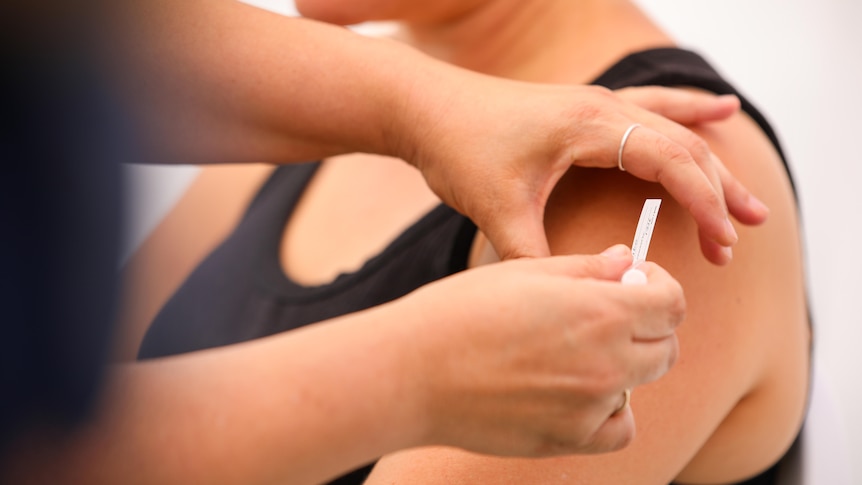 A needle going into a woman's arm.