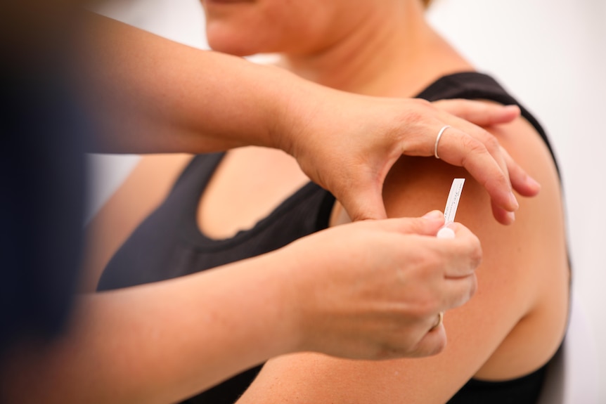 A needle going into a woman's arm.