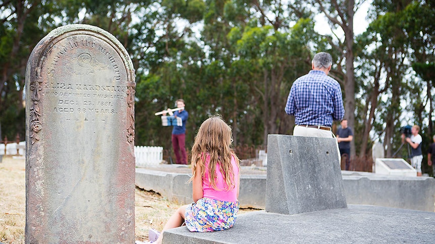 People gather at a cemetery.