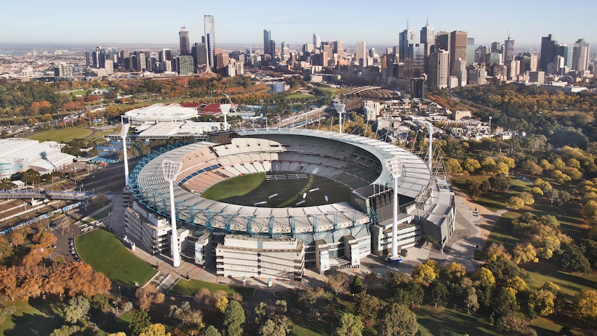 An aerial photo of the MCG with the Melbourne skyline in the background.