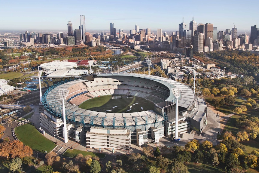 The MCG, as seen from above, with the Melbourne skyline in the background.
