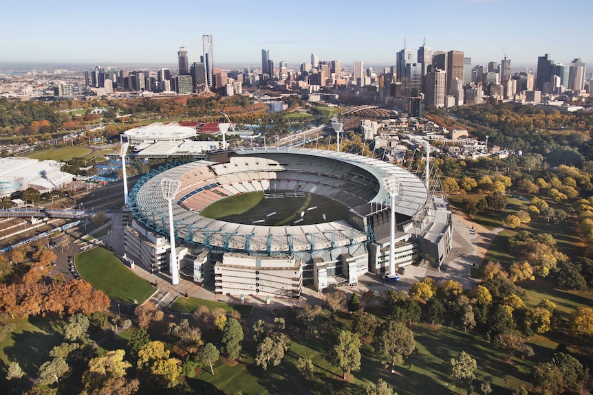 An aerial photo of the MCG with the Melbourne skyline in the background.