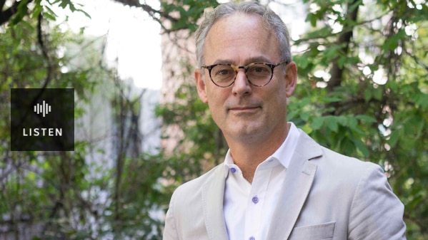 A man in a casual suit jacket standing. Has Audio.