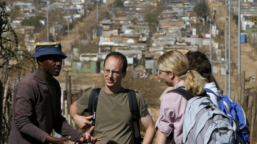 South African Lawrence Rolomana talks to tourists in Motsoaledi
