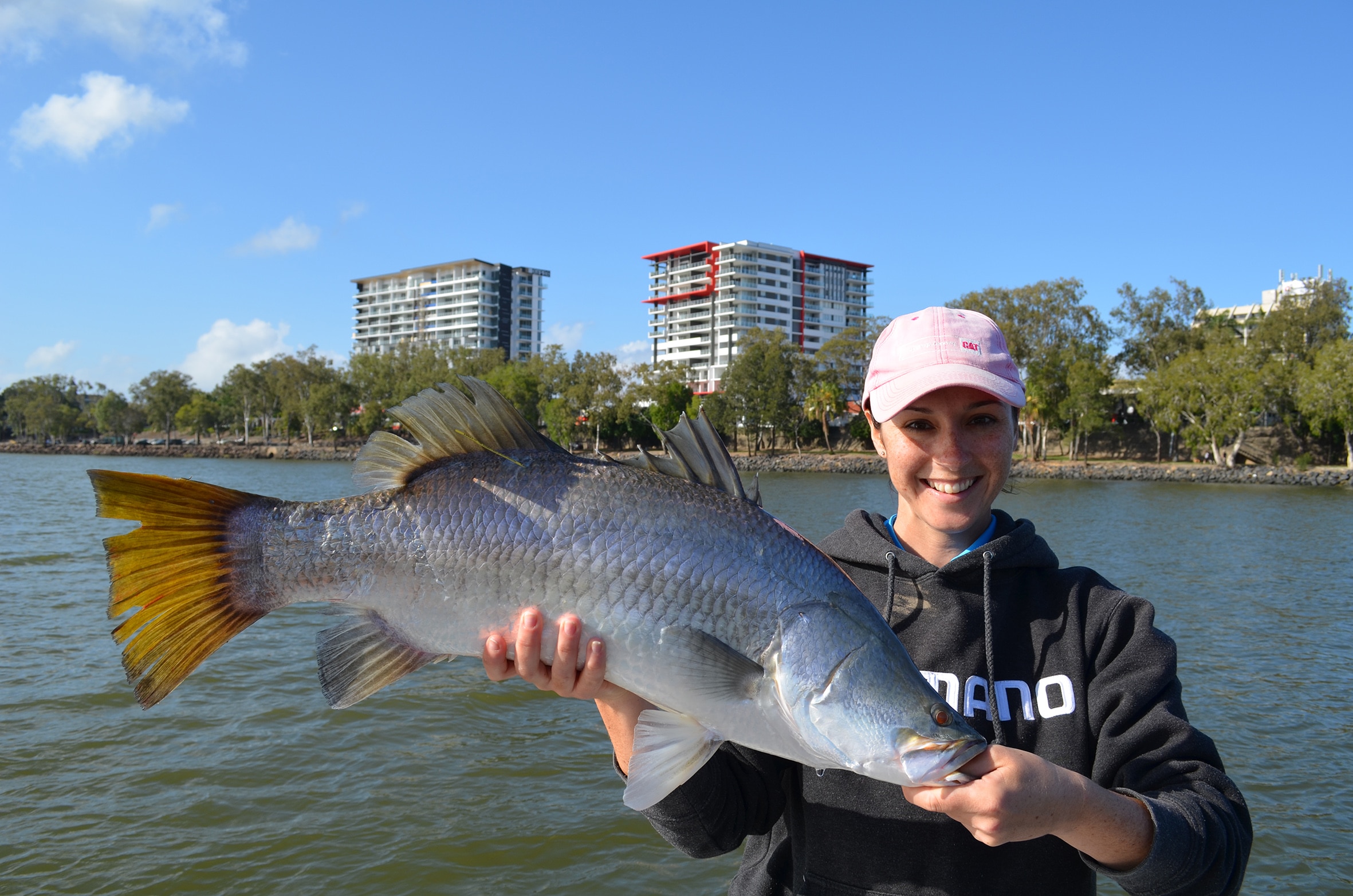 Una mujer presenta su barramundi capturado en el río Fitzroy, en la zona del CBD.
