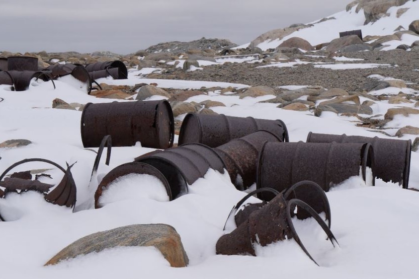 Rusted barrels covered in snow at the abandoned Wilkes station in Antarctica.