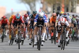 An Australian cyclist looks up as he goes past the finish line in a stage race having beaten his rivals in a sprint.