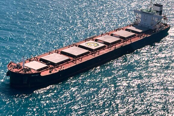 Bulk carrier floating in the ocean on a sunny day