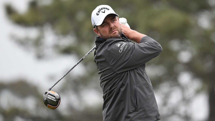 Marc Leishman holds a pose with his gold club behind him