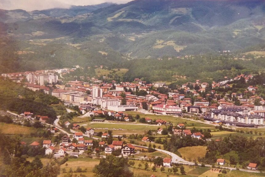 An archival photo of a town in Bosnia-Herzegovina, surrounded by mountains.