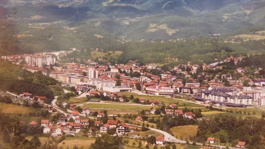 An archival photo of a town in Bosnia-Herzegovina, surrounded by mountains.