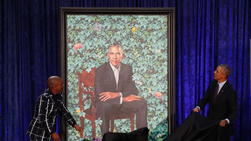 Artist Kehinde Wiley, left, and former US President Barack Obama, right, unveil his portrait.