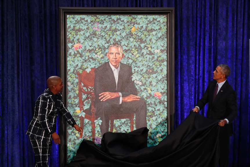 Artist Kehinde Wiley, left, and former US President Barack Obama, right, unveil his portrait.