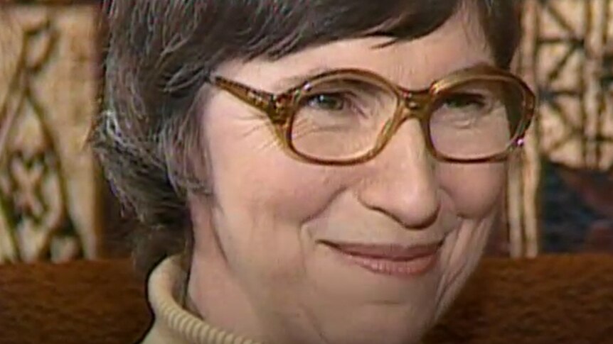 Close up of smiling woman with brown hair and spectacles