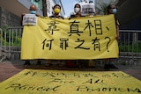 Hong Kongers hold up yellow banners outside the court where Apple Daily executives are being heard.