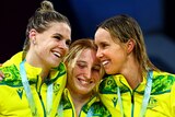 Shayna Jack, Mollie O'Callaghan and Emma McKeon hug on the 100m freestyle podium at the Commonwealth Games.