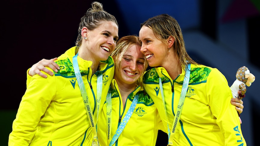 Shayna Jack, Mollie O'Callaghan and Emma McKeon hug on the 100m freestyle podium at the Commonwealth Games.