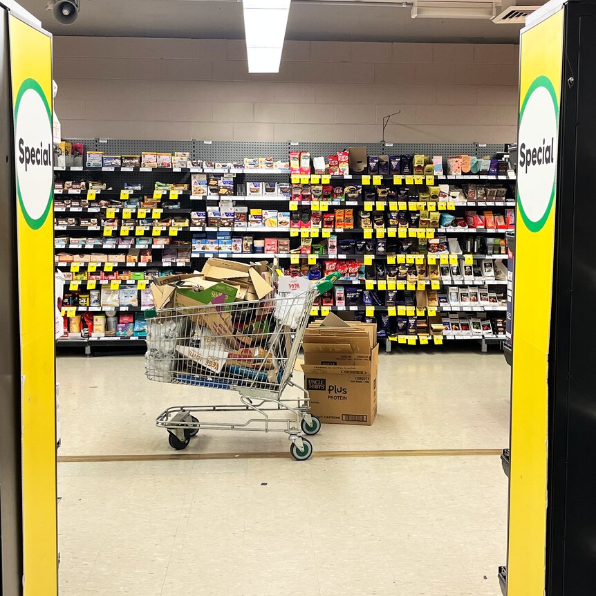 The view from a supermarket aisle, with discount stickers visible in the background. 