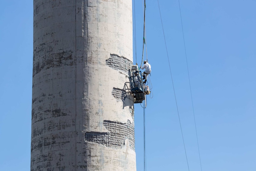 High above the Latrobe Valley a worker repairs one of the power plant's chimneys