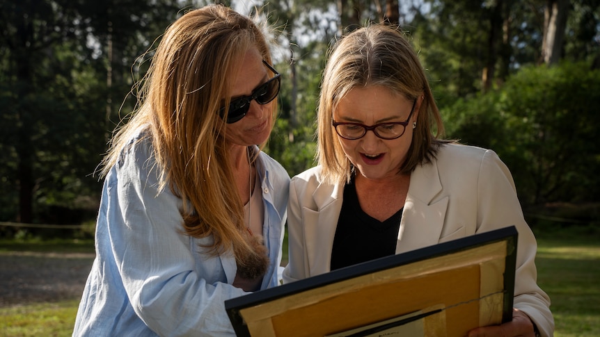 Jacinta Allan and Jacqui Wandin pictured look at a framed copy of Wiliam Barak's 1886 letter