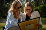 Jacinta Allan and Jacqui Wandin pictured look at a framed copy of Wiliam Barak's 1886 letter