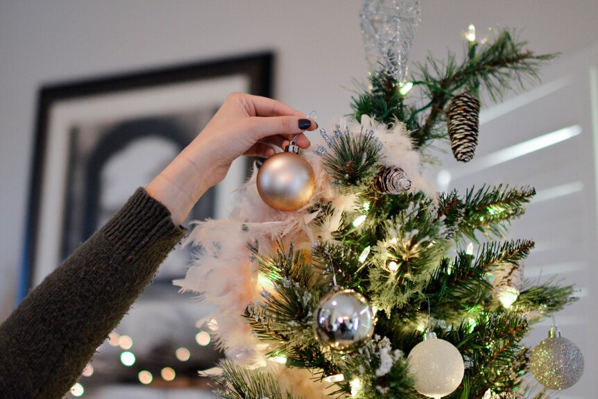 hanging a bauble on the xmas tree
