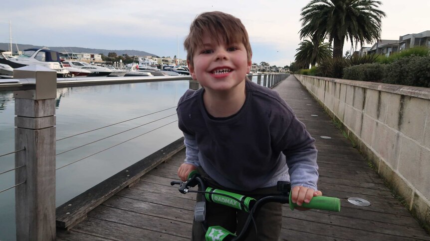 Max rides his bike beside the water