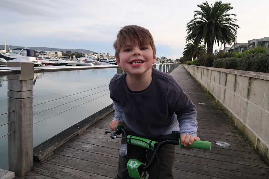 Max rides his bike beside the water