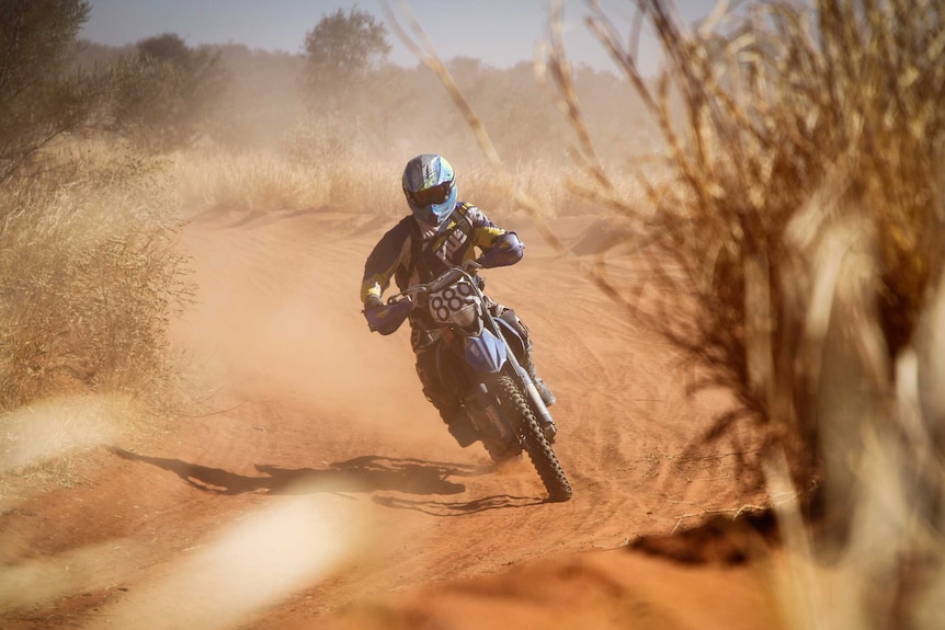 A man on a motorbike taking part in Finke Desert Race.