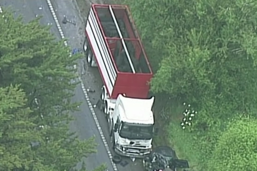 An aerial shot of a truck and the mangled wreckage of a black car.
