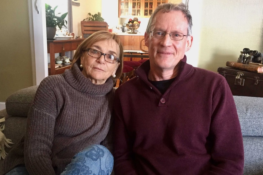 Carol and Graeme Bryson sit on their sofa