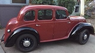 Photo of restored four-door red and black Morris Eight car in Canberra.