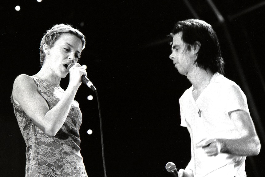 Kylie Minogue and Nick Cave sing into microphones on stage at the 1996 Big Day Out